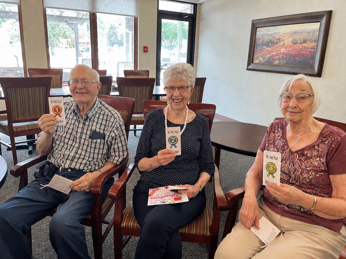 3 winners sitting in chairs and smiling into the camera
